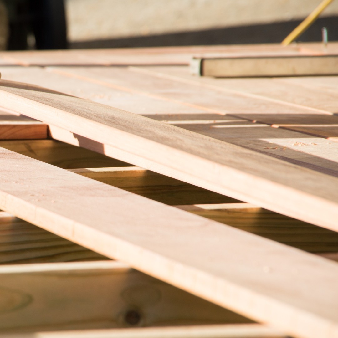 Man placing a plank of wood in a deck home renovation